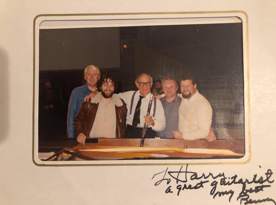 Abfotografierter Farbabzug im Passepartout: fünf Männer stehen hinter einem Flügel, in der Mitte ein älterer Mann mit Klarinette; unten handschriftlich „To Harry, a great guitarist, my best, Benny“.