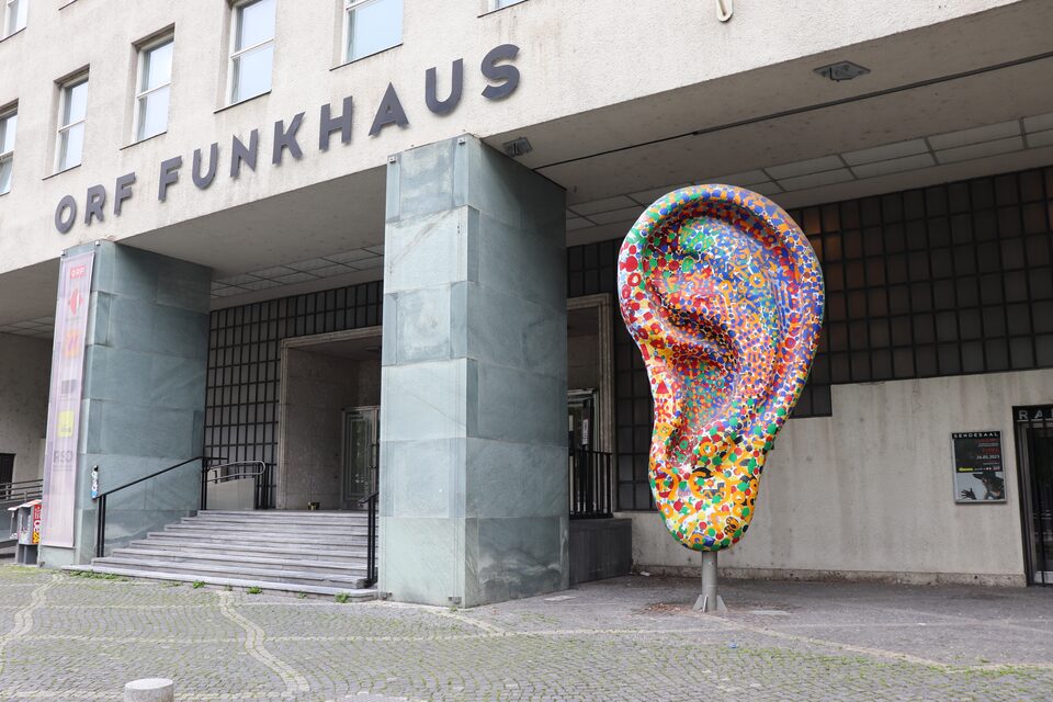 Eingang des Funkhauses des ORF (Österreichischer Rundfunk) in der Argentinierstraße in Wien, Österreich, im Mai 2023; rechts davon eine große, bunt bemalte Ohr-Skulptur, am rechten Bildrand der Eingang zum RadioKulturhaus. Bis 2022 sendete Ö1, das Kulturradio des ORF, von hier; das RadioKulturhaus bespielt die historischen Studios des Hauses weiter mit Konzerten und Gesprächen. Im Großen Sendesaal spielte Harry Pepl am Donnerstag, 25. September 1975 mit Hip Jargon und Werner Pirchner und am Montag, 14. Juni 1976 im Harald-Neuwirth-Konsort mit Lee Konitz.