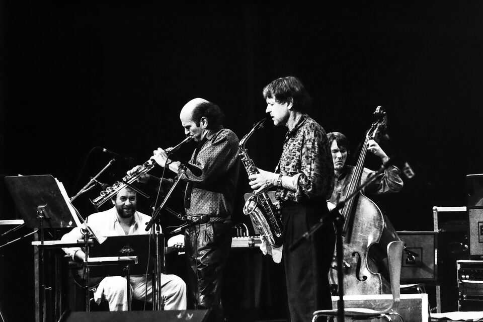 Jazzfestival Amiens, Frankreich, Mai 1987: Harry Pepl sitzend mit der Gitarre, vor ihm zwei Bläser, dahinter der Kontrabass. Laut Besetzung von „Men's Land“ Michel Portal, Dave Liebman und Jean-François Jenny-Clark.
