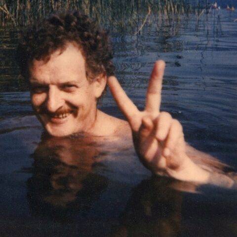 Werner Pirchner lächelnd im Ossiacher See in Kärnten, Österreich, mit erhobenem Victory-Zeichen, Polaroid von etwa 1995.
