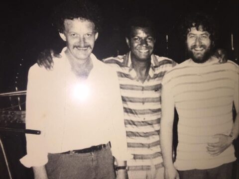 Schwarzweißfoto: Werner Pirchner, Jack DeJohnette und Harry Pepl Arm in Arm, alle drei lächeln in die Kamera.